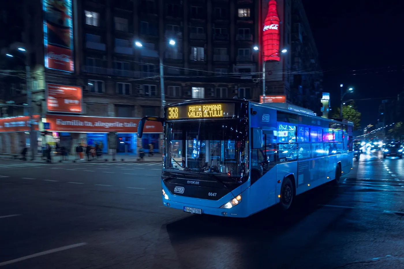 Un autobuz albastru pe o stradă din București, noaptea